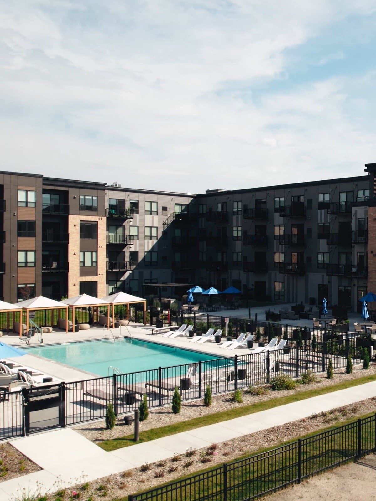 Aerial of the pool deck and blue umbrellas outside The Brooks apartment building