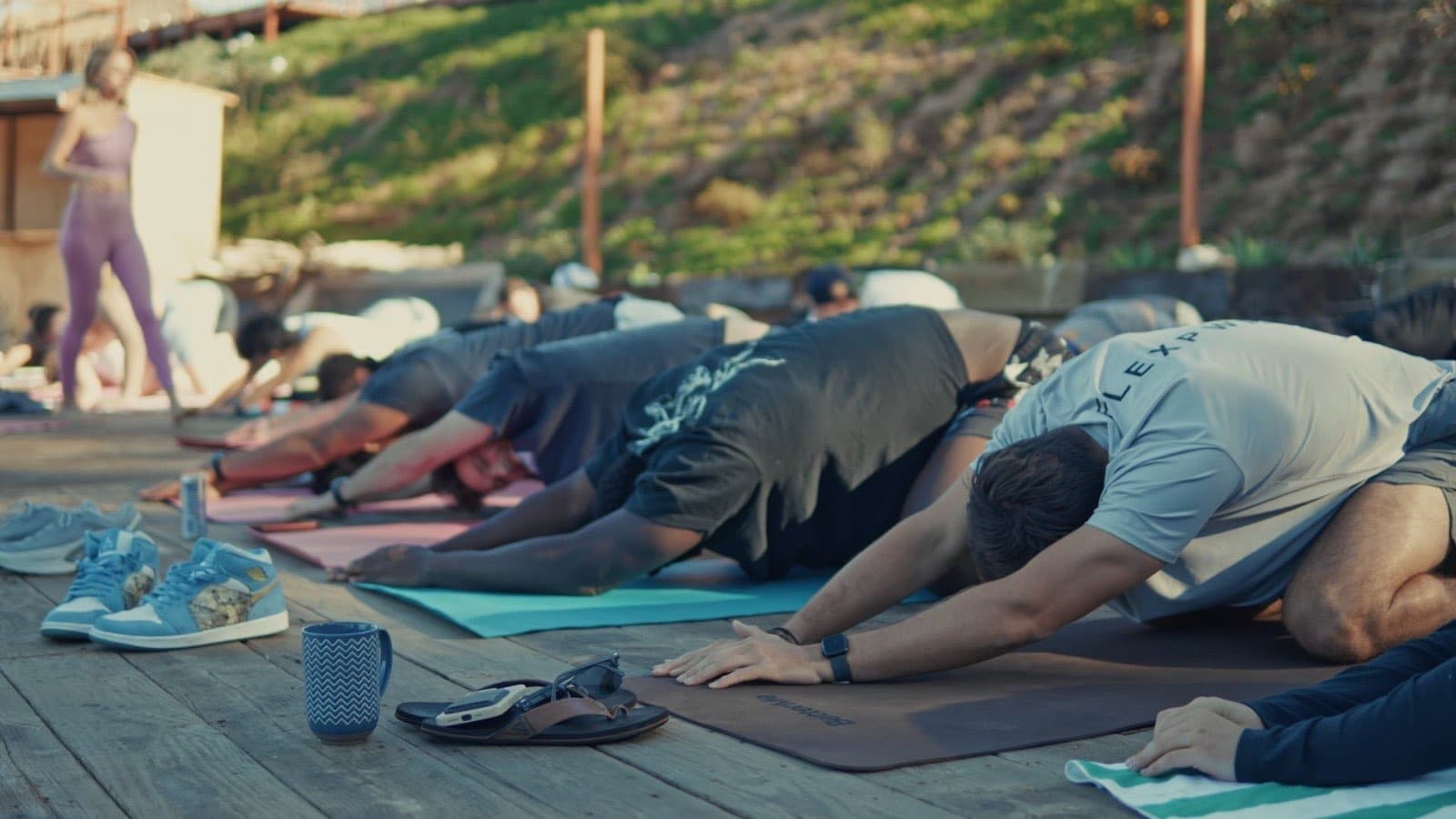 Flex PWR team stretching in child's pose on yoga mats at their San Diego retreat