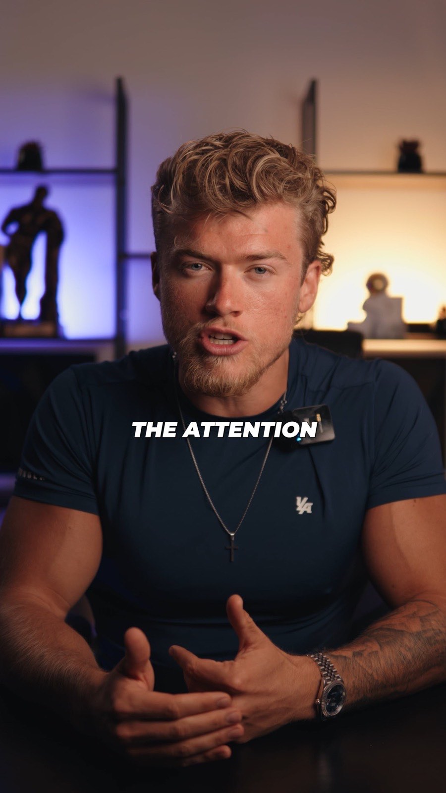 Brandon Clark seated in front of a purple-lit shelf unit, on-screen caption reading The attention