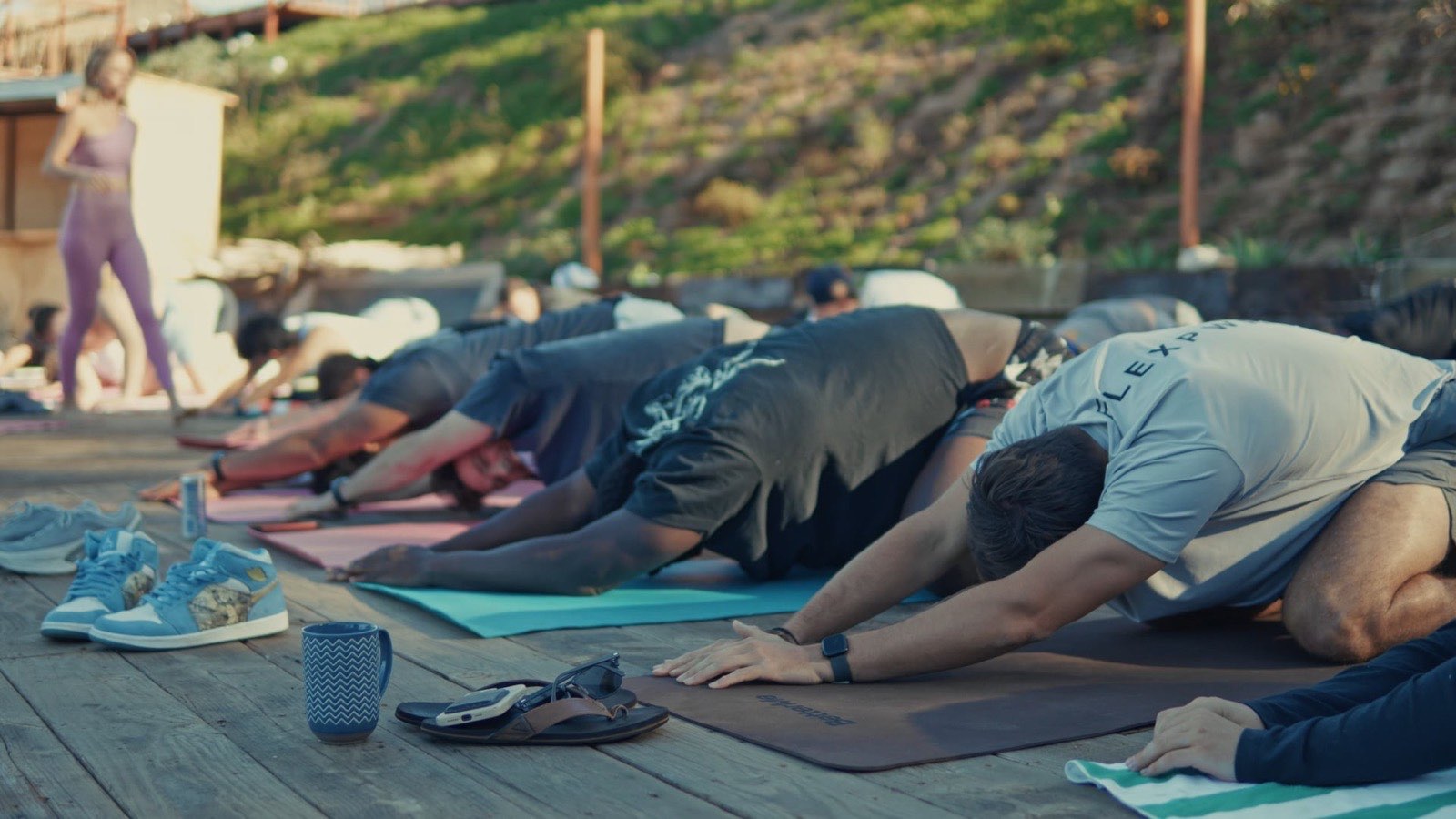 Flex PWR team stretching in child's pose on yoga mats at their San Diego retreat