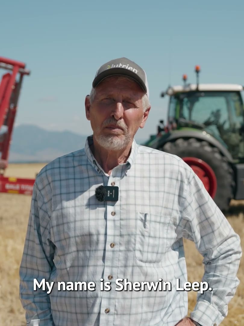 Farmer Sherwin Leep in a ball cap standing in front of a red tractor, subtitle reading My name is Sherwin Leep