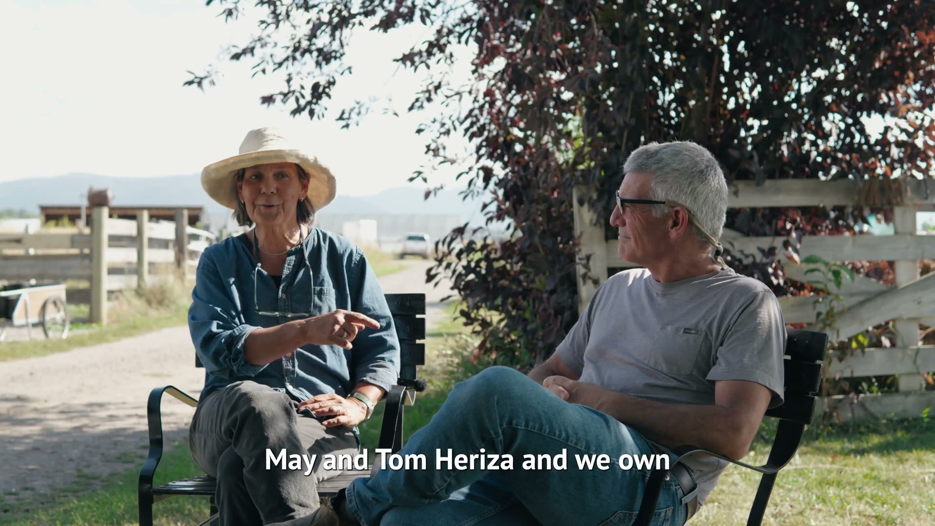 The owners of Four Daughters Farm seated together under a tree on their Bozeman farm